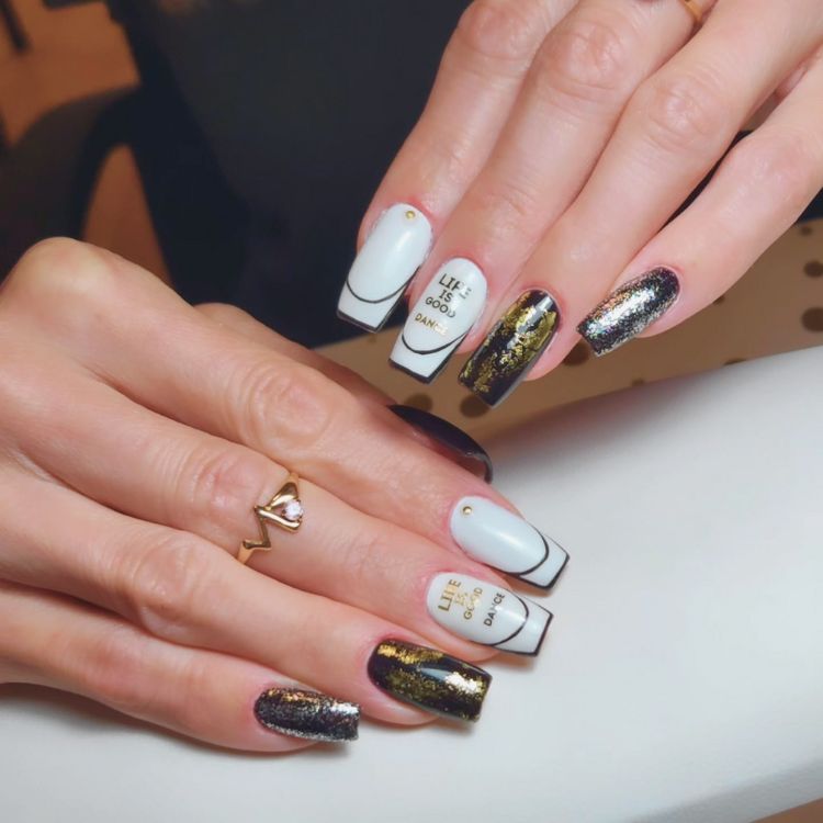 Professional nail art with white and gold glitter design